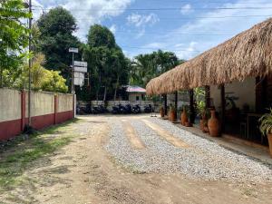 博洛德的住宿－Hotel Sebastian Panglao，草屋顶建筑旁边的土路