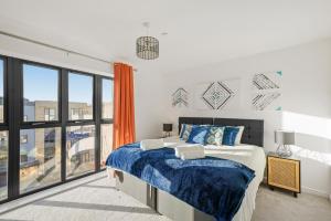 1 dormitorio con cama y ventana grande en Townhouse in Ebbsfleet sleeps 9 with free parking, en Greenhithe