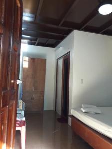 a bedroom with a bed and a door to a room at Bearby's Homestay Siargao - RH in Catangnan