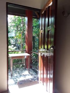an open door to a patio with a bench outside at Bearby's Homestay Siargao - RH in Catangnan