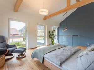 a bedroom with a large bed and a chair at Tasteful holiday home near Ossiacher lake in Töbring