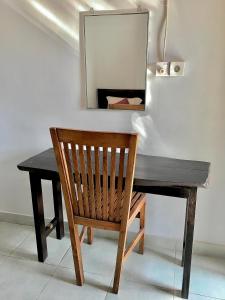 a wooden desk with a chair and a mirror at Wahyu Homestay 1 in Nusa Lembongan