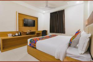 ein Hotelzimmer mit einem Bett und einem TV in der Unterkunft FabHotel Ananda Inn in Lucknow