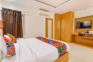 勒克瑙的住宿－FabHotel Ananda Inn，一间卧室配有一张大床和电视