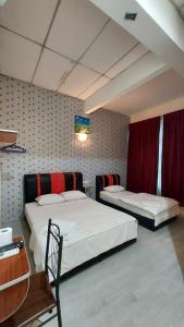 um quarto com 2 camas, uma mesa e uma secretária em Hotel Bestari em Malaca