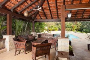 d'une terrasse avec des chaises, une table et un toit. dans l'établissement Great 5Bhk Villa Alibaug, à Alibaug