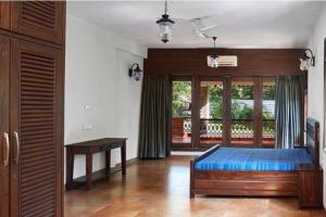 1 dormitorio con 1 cama azul en una habitación en Great 5Bhk Villa Alibaug, en Alibaug