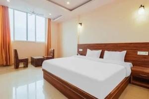 a bedroom with a large white bed and a window at Hotel Rabbit Hut in Dehradun