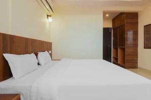 a bedroom with a large white bed and a closet at Hotel Rabbit Hut in Dehradun +16 photos