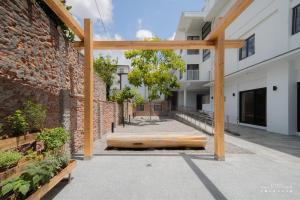 a wooden pergola next to a brick building at 山鄰山林青年文旅 forest 3030 hostel in Yuli