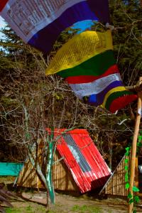 a colorful umbrella is flying over a house at SGM Camp & Cottage in Manāli