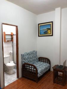 een woonkamer met een stoel en een toilet bij UFO House in Montañita