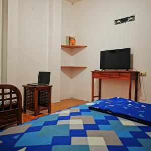 Schlafzimmer mit einem Bett, einem Schreibtisch und einem TV in der Unterkunft UFO House in Montañita