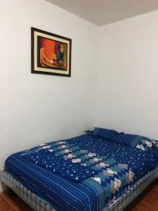 1 cama en un dormitorio con una foto en la pared en UFO House en Montañita