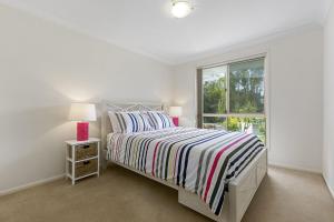 a white bedroom with a bed and a window at 21 David Street Noosa Heads in Noosa Heads