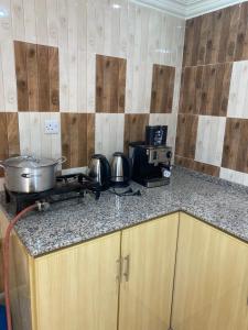 um balcão de cozinha com fogão, panelas e frigideiras em Dar Alhamra INN نزل دار الحمراء em Al Hamra