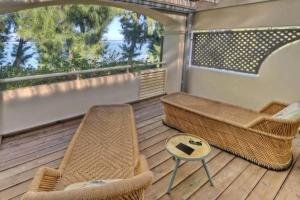 a balcony with wicker chairs and a table at La villa Caroline - La Saline les Bains in La Saline les Bains