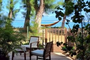 patio ze stołem i krzesłami oraz oceanem w obiekcie La villa Caroline - La Saline les Bains w mieście La Saline les Bains