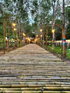 a long stone path with street lights and trees at ฮักฮิมเกี๋ยน รีสอร์ท น่าน Hug Him Kien in Nan