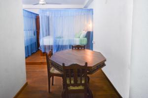 a table and chairs in a room with a bedroom at SEVENTY SEVEN GALLE in Galle