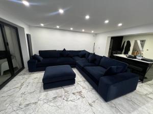 a living room with a blue couch and a piano at Penthouse Style Luxury 2 Bedroom House has Hot-Tub, extra fees apply in Birmingham