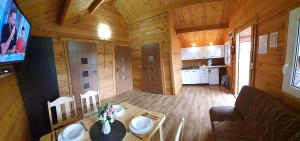 a small room with a table and a kitchen in a cabin at Wantaris 2 - domki letniskowe in Mielenko