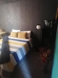 a bedroom with a bed with blue and white sheets and pillows at Phola at my place in Durban