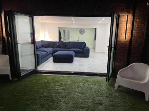 sala de estar con sofá azul y silla en Penthouse Style Luxury 2 Bedroom House has Hot-Tub, extra fees apply en Birmingham