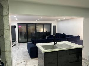 a living room with a blue couch and a sink at Penthouse Style Luxury 2 Bedroom House has Hot-Tub, extra fees apply in Birmingham