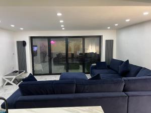 uma sala de estar com sofás azuis e uma grande janela em Penthouse Style Luxury 2 Bedroom House has Hot-Tub, extra fees apply em Birmingham