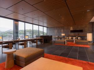 a large lobby with tables and chairs and windows at THE BLOSSOM KUMAMOTO in Kumamoto