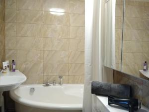 a bathroom with a sink and a toilet and a tub at Sunrise Apartment in Madona