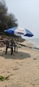 柴瑞海灘的住宿－Vintage Inn Homestay，海滩上的两把椅子和一把遮阳伞