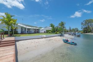 a boat on the water in front of a house at 21 Wesley Court Noosa Sound in Noosa Heads