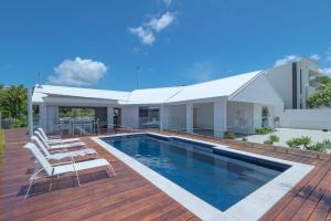 a house with a swimming pool and a deck at 21 Wesley Court Noosa Sound in Noosa Heads