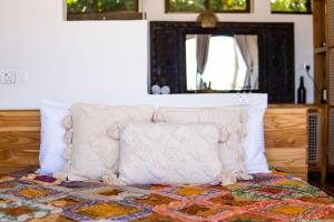 Una cama con dos almohadas encima. en CoCo Tree House @ Kima Zanzibar, Unique stay, en Bwejuu