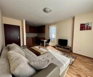 uma sala de estar com um sofá e uma mesa em Prime Apartments em Bansko