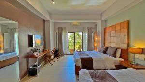 um quarto de hotel com duas camas e uma secretária e uma cama em Aloha Boracay Hotel em Boracay