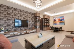 a living room with a television on a wall at Longer Homestay in Taitung City