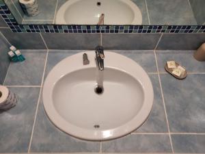 La salle de bains est pourvue d'un lavabo blanc et d'un miroir. dans l'établissement Hotel Sirenetta, à Anzio