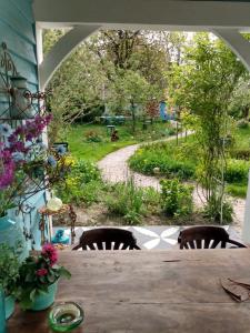 uma mesa com cadeiras e vista para um jardim em Wonderland em Pieterburen