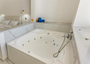 a large white bath tub in a bathroom at Limnionas Bay Village Hotel in Marathokampos