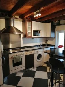 a kitchen with a stove and a washing machine at Centro-bahía de Santander. WIFI in Santander