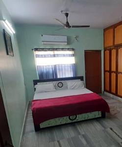 a bedroom with a bed with a red blanket at Nandita S Beach Bay Rest House By WB Inn in Visakhapatnam