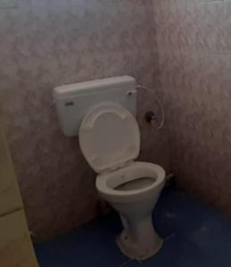 a bathroom with a white toilet in a room at Nandita S Beach Bay Rest House By WB Inn in Visakhapatnam
