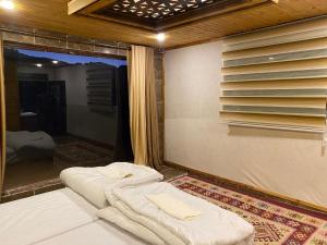 a room with two beds in front of a window at Desert Jewel Camp in Wadi Rum