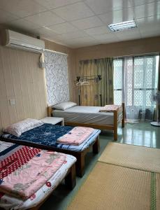 a room with three beds and two rugs at 枋寮枋居背包客棧Fang Ju Backpackers in Fangliao