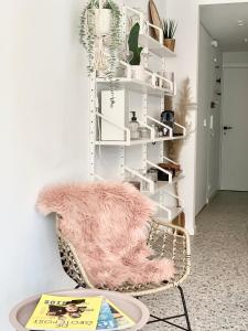 Pokój z krzesłem i różowym kocem w obiekcie Theodore Oostende-zorgeloos genieten in stijl op de perfecte locatie w Ostendzie
