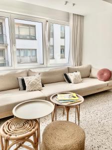 a living room with a couch and two tables at Theodore Oostende-zorgeloos genieten in stijl op de perfecte locatie in Ostend