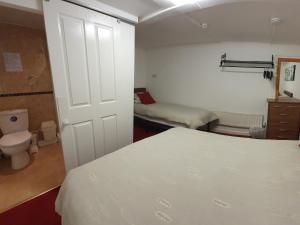 a bedroom with a bed and a bathroom with a toilet at Norwyn Court Holiday Apartments in Blackpool